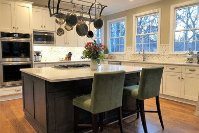 This is an example of a large transitional l-shaped eat-in kitchen in Baltimore with an undermount sink, shaker cabinets, white cabinets, quartz benchtops, multi-coloured splashback, marble splashback, stainless steel appliances, medium hardwood floors, with island, brown floor and grey benchtop.