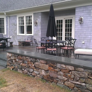 Blue stone patio and New England fieldstone capped sitting wall