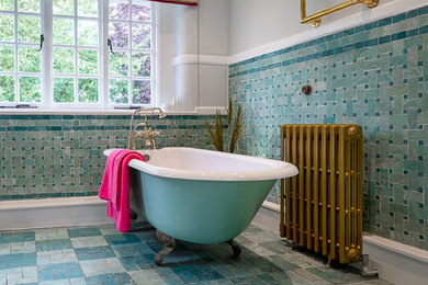 Mid-sized contemporary kids bathroom in Oxfordshire with blue cabinets, a freestanding tub, blue tile, ceramic tile, ceramic floors, blue floor, a hinged shower door and wallpaper.