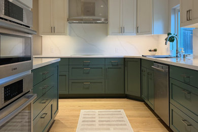 Mid-sized transitional l-shaped medium tone wood floor and brown floor eat-in kitchen photo in San Francisco with an undermount sink, recessed-panel cabinets, green cabinets, quartz countertops, white backsplash, quartz backsplash, stainless steel appliances and white countertops