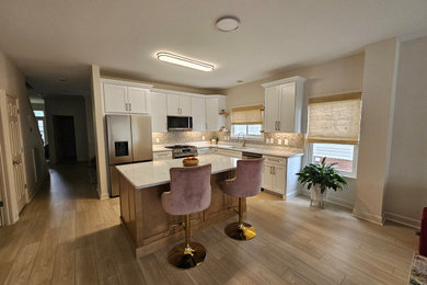 Inspiration for a mid-sized transitional l-shaped eat-in kitchen remodel in Nashville with shaker cabinets, white cabinets and an island