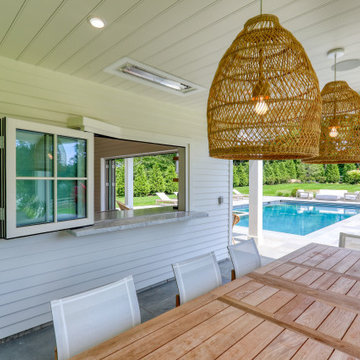 Covered patio dining beside the FoldFlat pass-through window to the pool