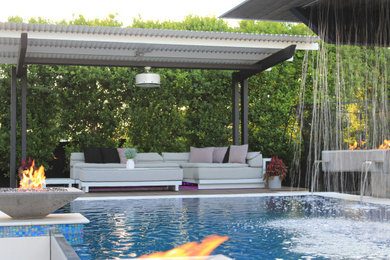 Photo of a mid-sized contemporary backyard custom-shaped aboveground pool in Phoenix with a water feature and decking.