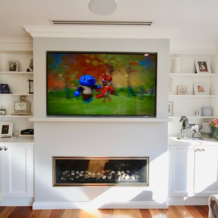 Photo of a medium sized traditional open plan home cinema in Sydney with medium hardwood flooring, brown floors, white walls and a built-in media unit.