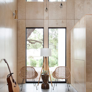 Idéer för ett mellanstort modernt allrum med öppen planlösning, med betonggolv, ett musikrum, bruna väggar och grått golv