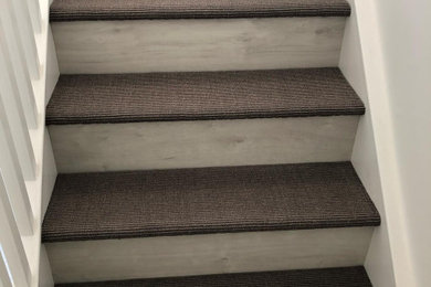 Imagen de escalera de estilo americano con escalones enmoquetados y contrahuellas con baldosas y/o azulejos
