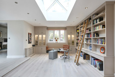 This is an example of a large contemporary study room in Essex with grey walls, light hardwood floors, a freestanding desk and grey floor.