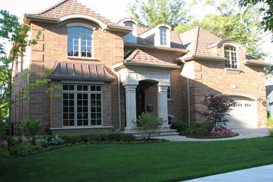 Inspiration for a large timeless two-story brick exterior home remodel in Chicago with a hip roof