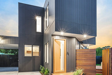 Inspiration for a large contemporary two-storey grey exterior in Melbourne with wood siding and a flat roof.