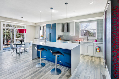 Inspiration for a mid-sized contemporary eat-in kitchen in Denver with an undermount sink, shaker cabinets, white cabinets, quartz benchtops, glass tile splashback, ceramic floors, with island, blue splashback, panelled appliances and grey benchtop.