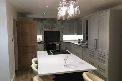 This is an example of a large contemporary kitchen/diner in West Midlands with shaker cabinets, grey cabinets, quartz worktops and an island.