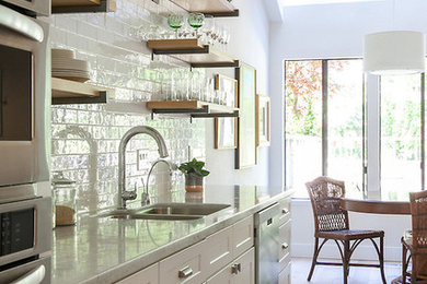 Inspiration for a mid-sized timeless single-wall light wood floor and brown floor eat-in kitchen remodel in San Francisco with an undermount sink, shaker cabinets, white cabinets, quartz countertops, white backsplash, subway tile backsplash, stainless steel appliances, an island and gray countertops
