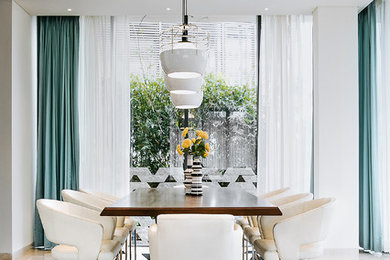 This is an example of a contemporary separate dining room in Bengaluru with white walls and beige floor.