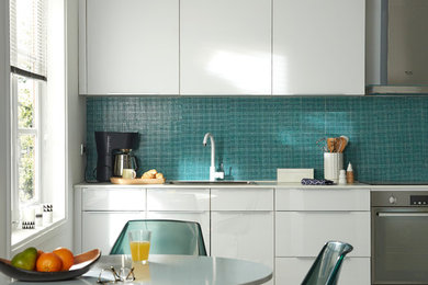 Aménagement d'une cuisine américaine linéaire contemporaine de taille moyenne avec un évier posé, des portes de placard blanches, une crédence bleue, un électroménager en acier inoxydable, un sol en carrelage de céramique et aucun îlot.