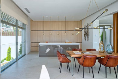 Foto de cocina lineal y rectangular actual grande abierta con armarios con paneles lisos, puertas de armario de madera clara y una isla