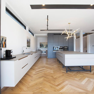 Huge contemporary kitchen pantry designs - Inspiration for a huge contemporary single-wall medium tone wood floor kitchen pantry remodel in Gold Coast - Tweed with an undermount sink, shaker cabinets, white cabinets, quartz countertops, black appliances and an island