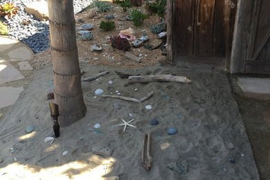 This is an example of a medium sized nautical back patio in Santa Barbara with gravel and no cover.