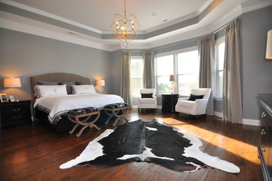 Large trendy master medium tone wood floor bedroom photo in Charlotte with blue walls