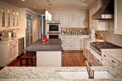 This is an example of a traditional u-shaped eat-in kitchen in Houston with white cabinets.