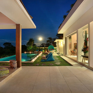 他の地域の大きい長方形トロピカルスタイルのおしゃれなプール (天然石敷き) の写真