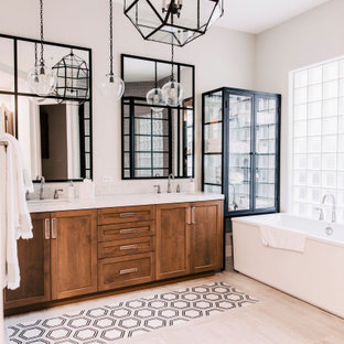 Klassisches Badezimmer mit Schrankfronten im Shaker-Stil, hellbraunen Holzschränken, freistehender Badewanne, grauer Wandfarbe, Unterbauwaschbecken, beigem Boden, weißer Waschtischplatte, Doppelwaschbecken und eingebautem Waschtisch in Phoenix