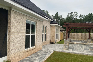 Diseño de patio tradicional grande en patio trasero con adoquines de hormigón y pérgola