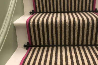 Photo of a medium sized bohemian straight staircase in Sussex with carpeted risers.