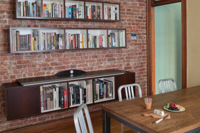 Inspiration for a mid-sized modern light wood floor, beige floor and brick wall kitchen/dining room combo remodel in New York with yellow walls