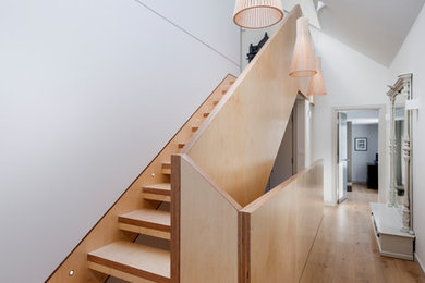 Design ideas for a contemporary wood u-shaped staircase in Sussex with wood risers and wood railing.