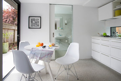 Contemporary single-wall eat-in kitchen in San Francisco with flat-panel cabinets and white cabinets.