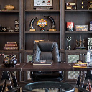 Inspiration för stora klassiska hemmabibliotek, med röda väggar, ljust trägolv, ett fristående skrivbord och beiget golv