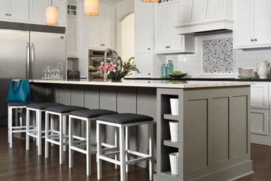 Eat-in kitchen - mid-sized transitional l-shaped dark wood floor and brown floor eat-in kitchen idea in Atlanta with shaker cabinets, white cabinets, quartzite countertops, white backsplash, subway tile backsplash, stainless steel appliances and an island