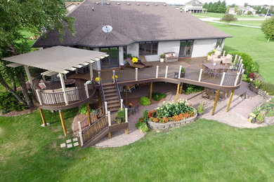 Large trendy backyard deck photo in Other with a pergola