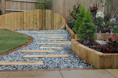 Photo of a medium sized modern back formal partial sun garden for summer in Berkshire with a fire feature and a wood fence.