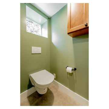 Modern Basement Toilet Room with Wall-Mounted Toilet and Sage Green Walls