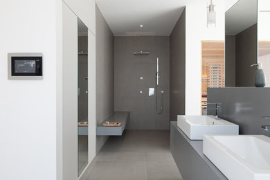 This is an example of a large modern bathroom in Nuremberg with a curbless shower, gray tile, white walls, a vessel sink and an open shower.