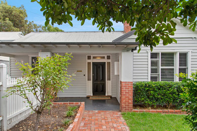 This is an example of a mid-sized traditional one-storey grey house exterior in Melbourne with wood siding, a metal roof, a grey roof and board and batten siding.