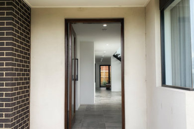 Photo of a large modern entryway in Melbourne.