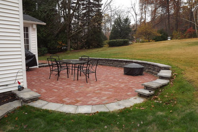Example of a mid-sized classic backyard brick patio design in Orange County with no cover