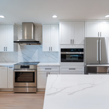 Modern White Shaker Kitchen with Navy Blue Island and Waterfall Quartz Counterto