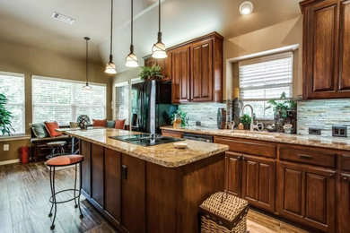 Example of a large transitional u-shaped medium tone wood floor and brown floor eat-in kitchen design in Dallas with an undermount sink, shaker cabinets, light wood cabinets, granite countertops, multicolored backsplash, matchstick tile backsplash, stainless steel appliances, an island and multicolored countertops