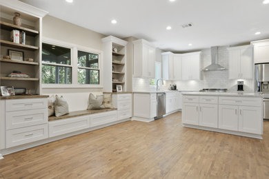 Inspiration for a mid-sized traditional u-shaped eat-in kitchen in Atlanta with a farmhouse sink, raised-panel cabinets, white cabinets, quartz benchtops, white splashback, ceramic splashback, stainless steel appliances, with island, beige floor and grey benchtop.