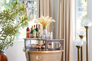 Example of a small island style light wood floor home bar design in Los Angeles with no sink