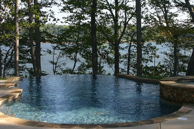 Inspiration for a mid-sized transitional backyard concrete paver and custom-shaped infinity hot tub remodel in Charlotte