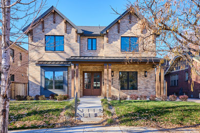 Elegant brown two-story brick exterior home photo in Denver with a shingle roof and a gray roof