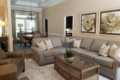 Living room - mid-sized transitional open concept medium tone wood floor and brown floor living room idea in Charlotte with beige walls, a standard fireplace and a wall-mounted tv