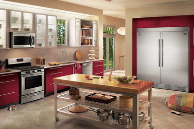Large transitional porcelain tile and brown floor kitchen photo in New Orleans with an undermount sink, flat-panel cabinets, red cabinets, brown backsplash, mosaic tile backsplash, stainless steel appliances, an island and white countertops