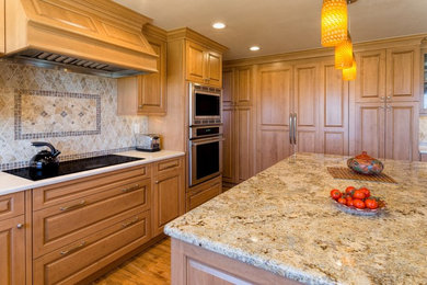 Eat-in kitchen - large traditional u-shaped medium tone wood floor eat-in kitchen idea in Albuquerque with a double-bowl sink, light wood cabinets, granite countertops, beige backsplash, stone tile backsplash, paneled appliances, an island and raised-panel cabinets