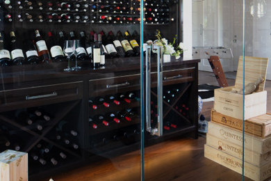 Wine cellar - mid-sized transitional medium tone wood floor and brown floor wine cellar idea in Detroit with display racks