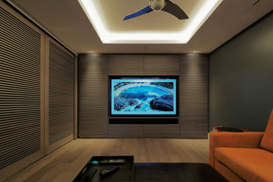 Home theater - mid-sized modern enclosed light wood floor and gray floor home theater idea in Vancouver with gray walls and a media wall